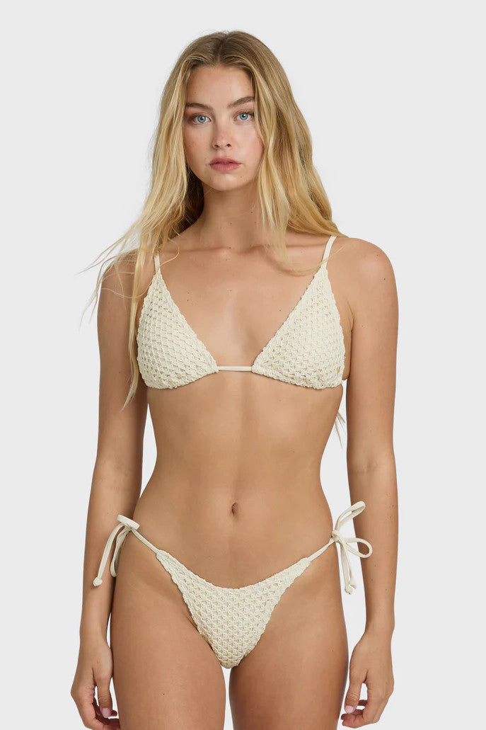 Woman wearing a beige bikini set on a white background
