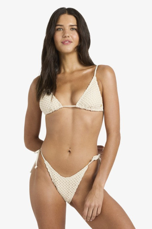 Woman wearing a beige bikini set on a white background