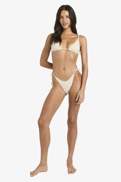 Woman wearing a beige bikini on a white background