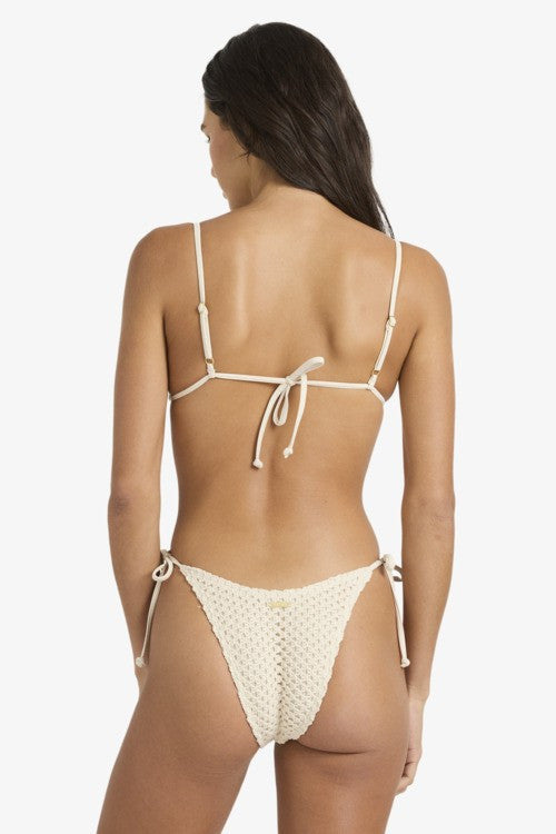 Woman wearing a beige bikini with thin straps on a white background