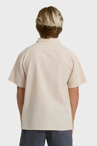 Person wearing a beige polo shirt on a white background
