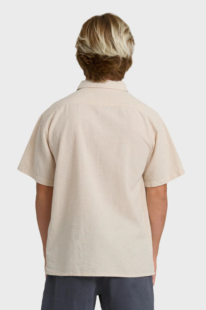 Person wearing a beige polo shirt on a white background