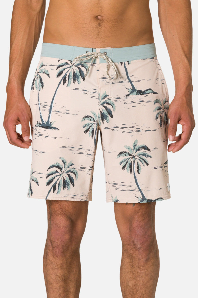 Man wearing tropical patterned shorts on a white background