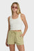 Woman wearing a white tank top and green shorts on a white background
